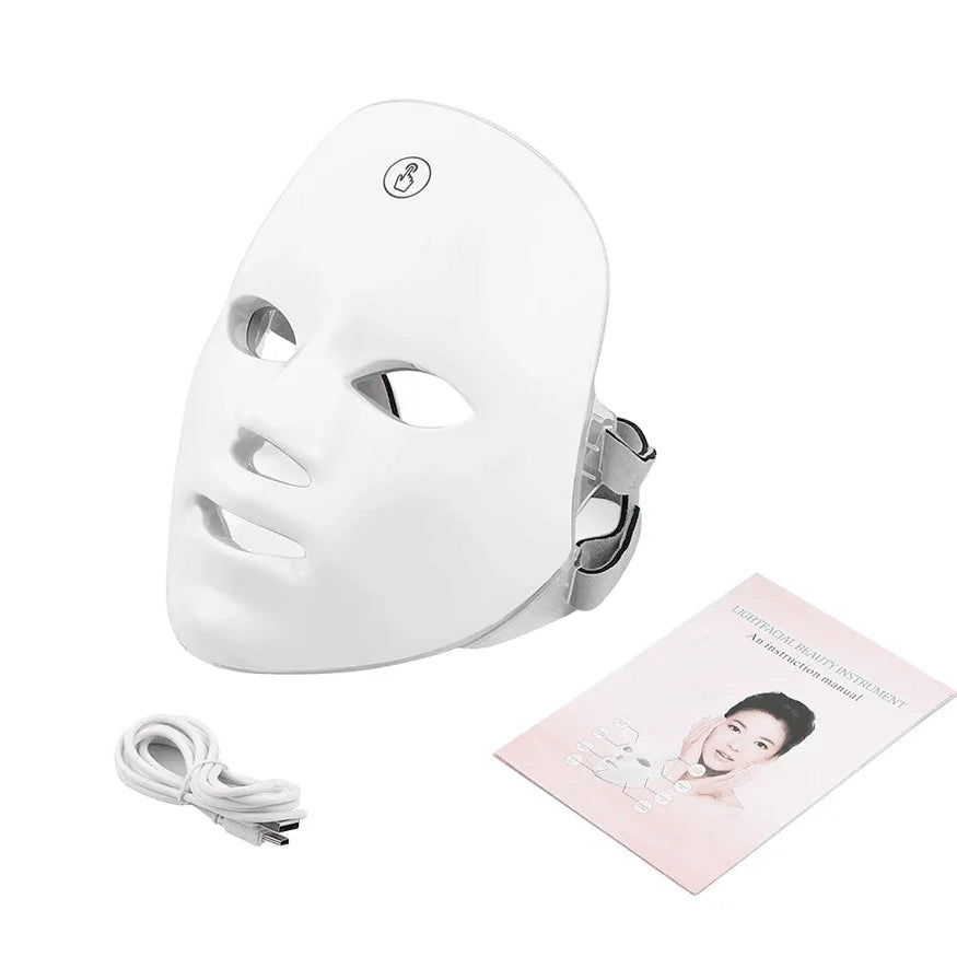White LED face mask with charging cable and user manual on a white background